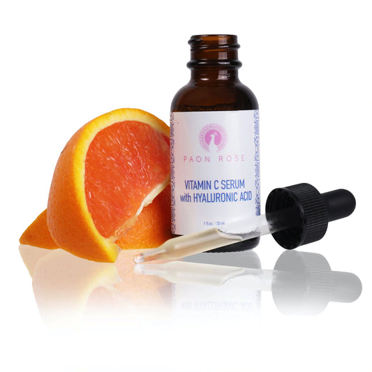 vitamin c serum with hyaluronic acid open bottle beside dropper cap and slices of orange