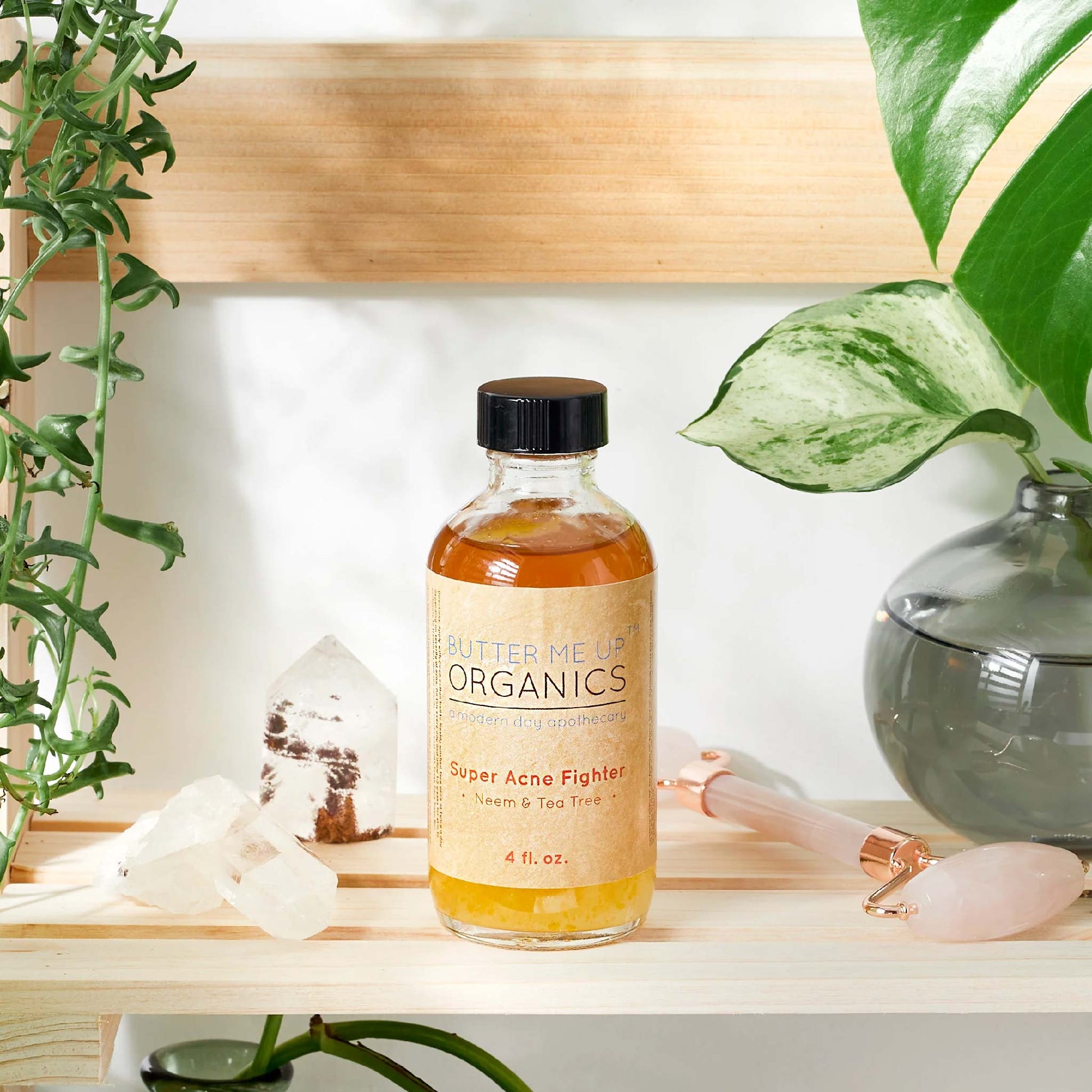 eco-friendly glass bottle of organic  pimple treatment on top of a table beside green plants