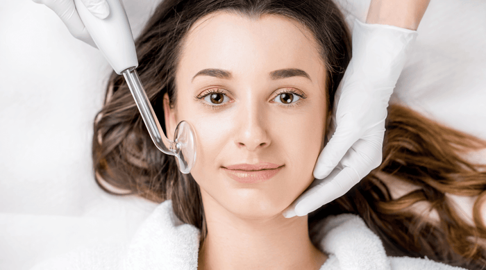 woman receiving benefits of high frequency wand facial