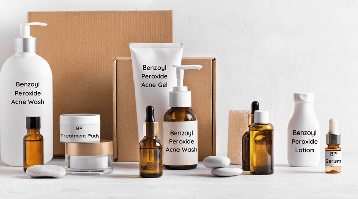 assortment of benzoyl peroxide acne treatment  products and boxes on a white table