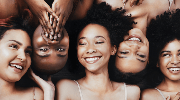 faces of smiling  women with melanated skin