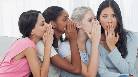 women whispering the secret to skin aging to their friend